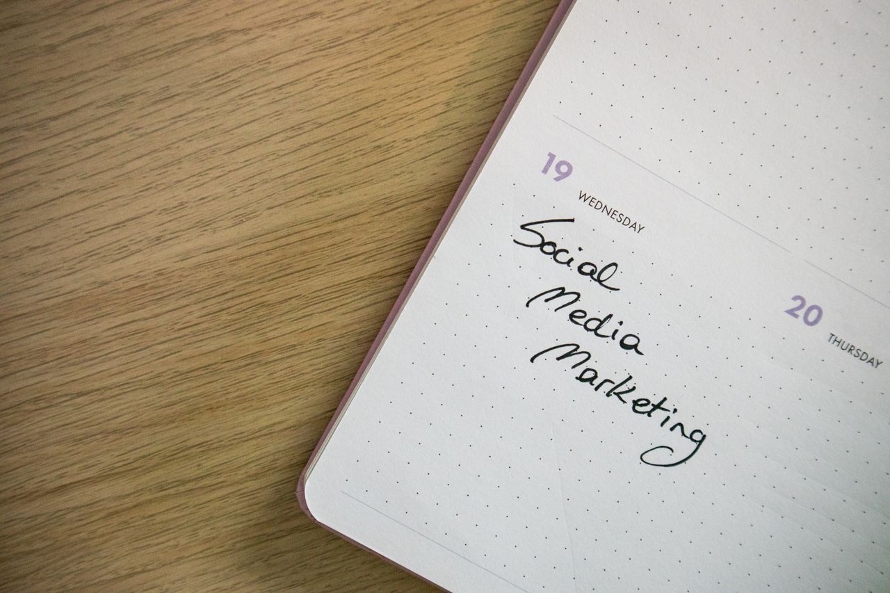 Gros plan sur une page de carnet avec l’inscription Social Media Marketing écrite à la main.