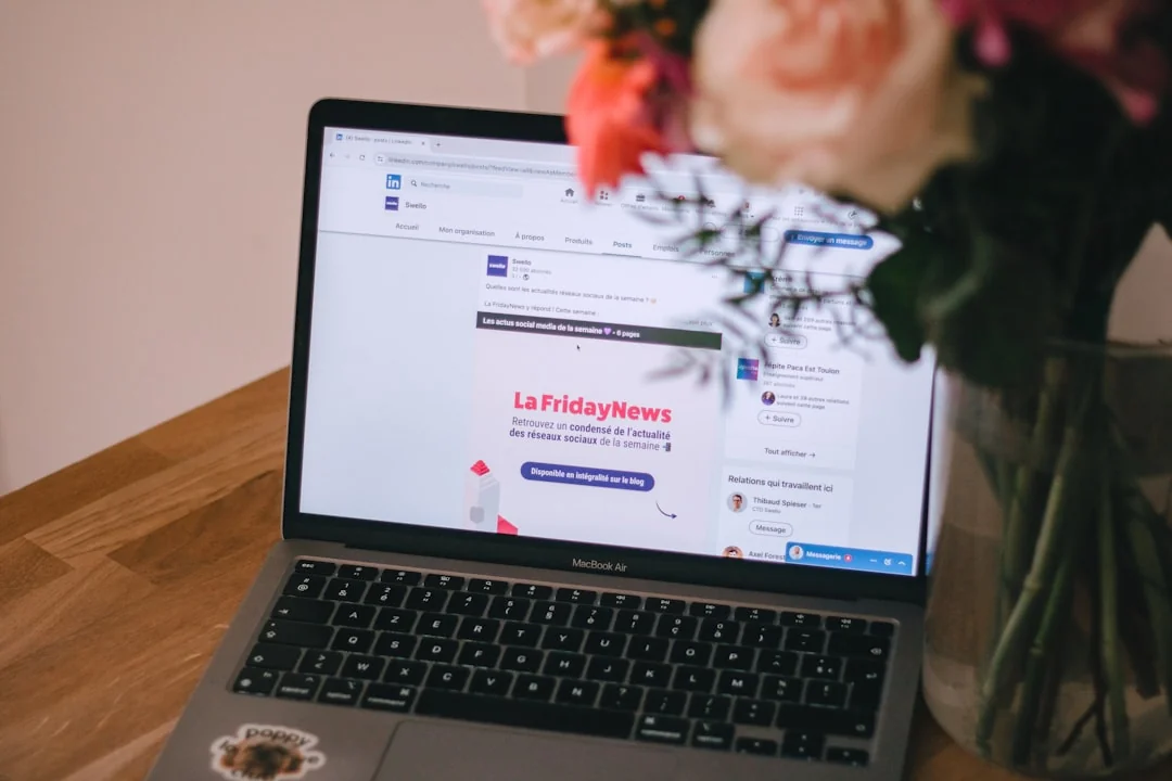 Smartphone affichant le logo LinkedIn avec clavier et grand logo en arrière-plan, ambiance business.